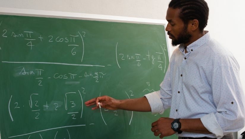 professor escrevendo na lousa 825x470